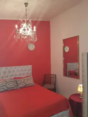 a red bedroom with a bed and a chandelier at MAMAJUANA BEACH APARTAMENTS in Boca Chica