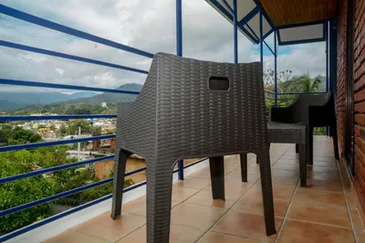 a chair sitting on top of a balcony at Hotel Jaraba in Jarabacoa
