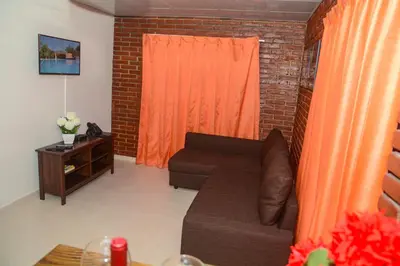 a living room with a couch and an orange curtain at Hotel Jaraba in Jarabacoa