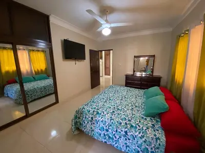 a bedroom with a bed and a mirror and a television at Oasis de paz in Jarabacoa