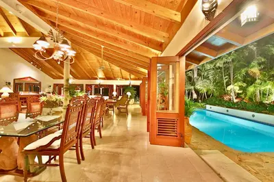 a dining room with a table and chairs and a pool at CASA NOSTRA RESORT by Klabhouse in La Romana