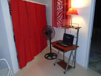 a room with a desk with a laptop and a red curtain at Guesthouse Villa La Isla in La Romana