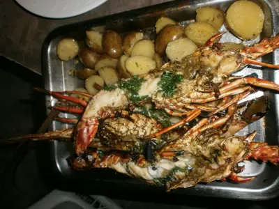 a tray of food with a crab and potatoes at Guesthouse Villa La Isla in La Romana