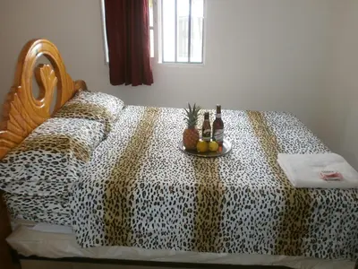 a bed with a leopard printspread with bottles and fruit on it at Guesthouse Villa La Isla in La Romana