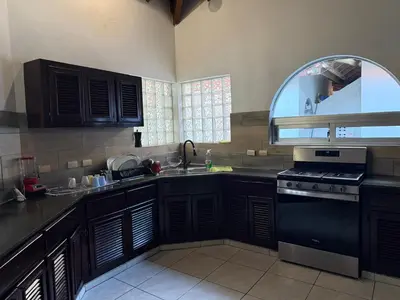 a kitchen with black cabinets and a sink and a window at Villas for Vacation 32-18-6 in Sosúa