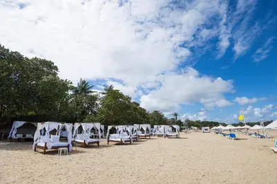 a group of chairs and umbrellas on a beach at Blue JackTar in San Felipe de Puerto Plata