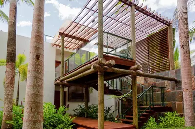 a house with a balcony and palm trees at Sublime Samana in Las Terrenas