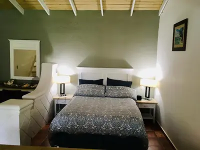 a bedroom with a bed with two lamps and a mirror at bungalow 3116 vue sur piscine in Las Galeras