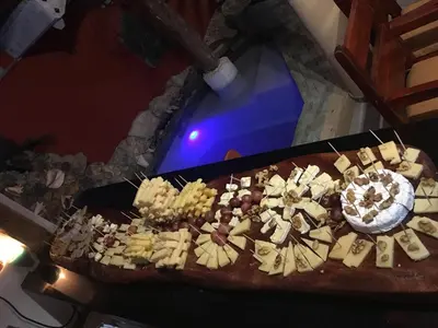 a pizza with cheese and other food on a table at Cabrera Chalet boutique hotel in Cabrera