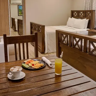 a table with a plate of food and a glass of orange juice at Hotel Riazor in Santo Domingo