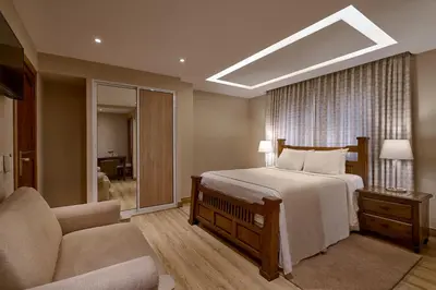 a bedroom with a bed and a chair and a couch at Hotel Riazor in Santo Domingo