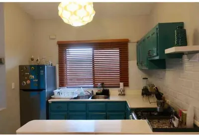 a kitchen with green cabinets and a blue refrigerator at Lugo`s guest room in Punta Cana