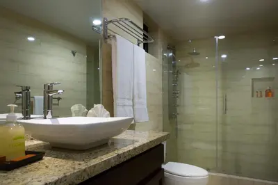 a bathroom with a white sink and a shower at Plaza Florida Suites in Santo Domingo