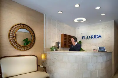 a woman talking on a cell phone behind a counter at Plaza Florida Suites in Santo Domingo