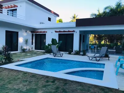 a villa with a swimming pool in front of a house at Villa Luce in Las Terrenas