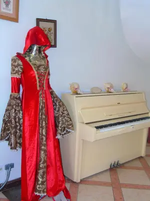 a statue of a person in a red dress standing next to a piano at Piergiorgio Palace Hotel in Sosúa