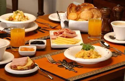 a table topped with plates of food and bread at Hotel Colonial Blanco in Santo Domingo
