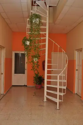 a spiral staircase in a room with orange walls at Hotel Colonial Blanco in Santo Domingo