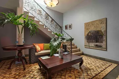 a living room with a couch and a table and stairs at Hotel Villa Colonial in Santo Domingo