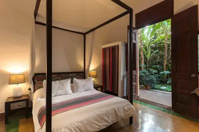 a bedroom with a canopy bed and a sliding glass door at Hotel Villa Colonial in Santo Domingo