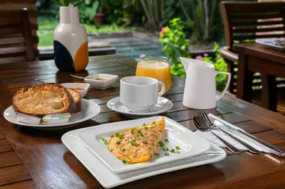 a table with a plate of omelet and bread at Hotel Villa Colonial in Santo Domingo