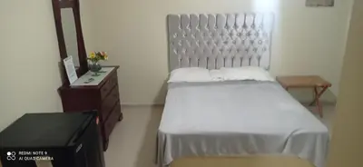 a bedroom with a bed and a dresser and a mirror at Los Palmares Guest House & Eventos in San Cristóbal