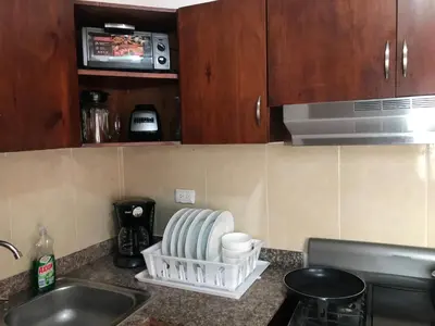 a kitchen counter with a sink and a microwave at lujoso apto con terraza para barbecue in Santiago de los Caballeros