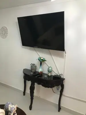 a black table with a flat screen tv on a wall at lujoso apto con terraza para barbecue in Santiago de los Caballeros