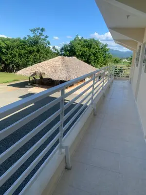 a balcony of a house with a thatch roof at Hotel Anedi in Concepción de La Vega