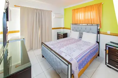 a bedroom with a bed and a tv in it at Hotel La Casona Dorada in Santo Domingo