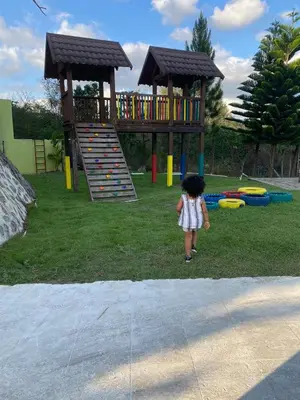 a little girl standing in front of a playground at Ximenoa Rivers Villa Relax in Jarabacoa