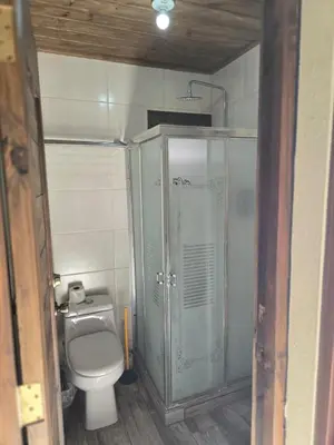 a small bathroom with a toilet and a shower at Ximenoa Rivers Villa Relax in Jarabacoa