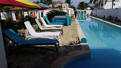 a group of chairs sitting next to a swimming pool at Villa de Colores 3 Rooms 5 king Beds in Sosúa