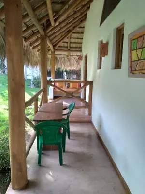 a patio with a wooden table and a bench at Casa Flamingo in Las Terrenas