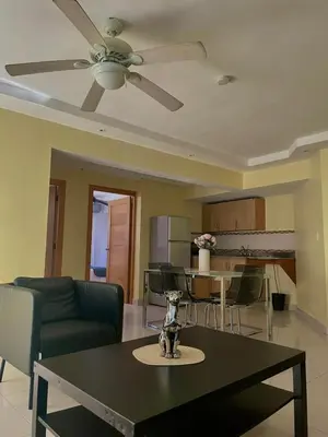 a living room with a ceiling fan and a table at City Caribbean Hotel Boutique in Santo Domingo