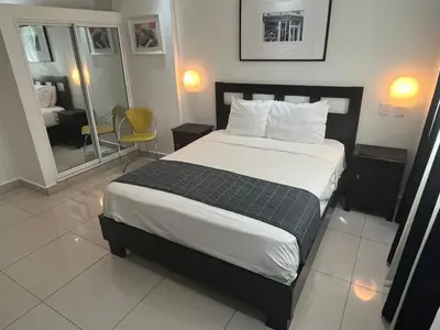 a bedroom with a large bed and a mirror at City Caribbean Hotel Boutique in Santo Domingo