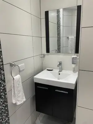a white bathroom with a sink and a mirror at City Caribbean Hotel Boutique in Santo Domingo