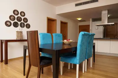 a dining room with a table and blue chairs at Sybaris Suites & Residences in Juan Dolio