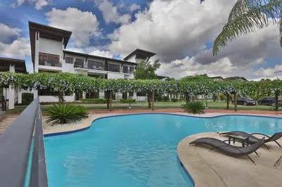 a swimming pool in front of a building at Sybaris Suites & Residences in Juan Dolio