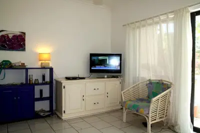 a living room with a tv and a chair at Beachfront apartment near Cabarete in Cabarete