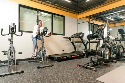 a woman on a bike in a gym at Apartamentos Roman in Santo Domingo