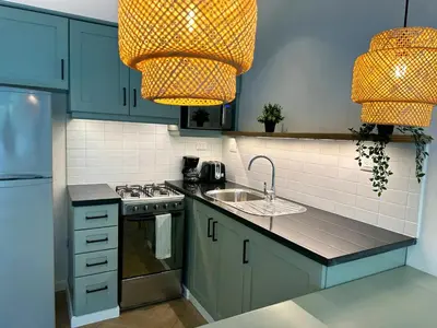 a kitchen with blue cabinets and a sink and a chandelier at Bahia Residence Cabarete in Cabarete