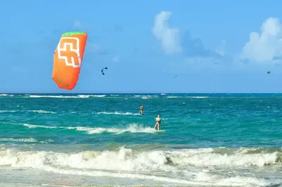 two people riding the waves in the ocean with a kite at Bahia Residence Cabarete in Cabarete