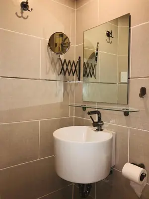 a bathroom with a white sink and a mirror at Estancia Riviera Colonial I in Santo Domingo