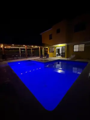 a large swimming pool lit up at night at Playa Dorada Mountainview Villa in San Felipe de Puerto Plata