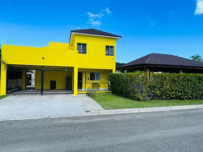 a yellow house on the side of a street at Playa Dorada Mountainview Villa in San Felipe de Puerto Plata