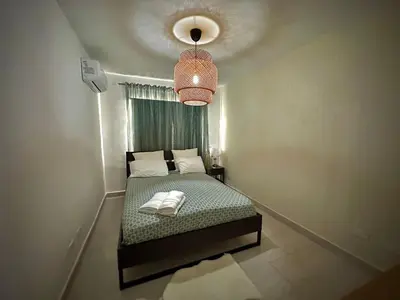 a small bedroom with a bed and a pendant light at Beautiful & Comfortable Apartment near Colonial Zone in Santo Domingo
