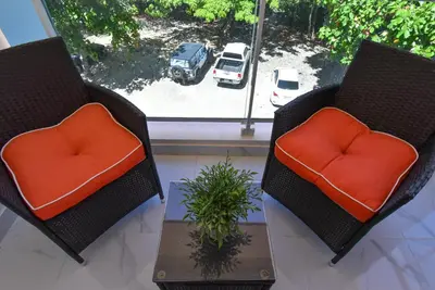 two chairs with orange cushions sitting next to a window at Rosil Place in San Felipe de Puerto Plata