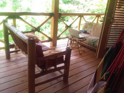 a room with a hammock and a laptop on a porch at Welcoming House in Las Galeras with Stunning Sea View in Las Galeras