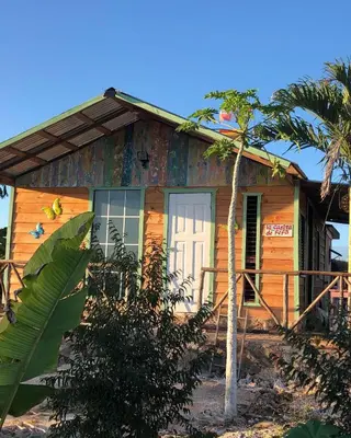 a small wooden house with a white door at GuaiGüí Bayahibe in Bayahibe